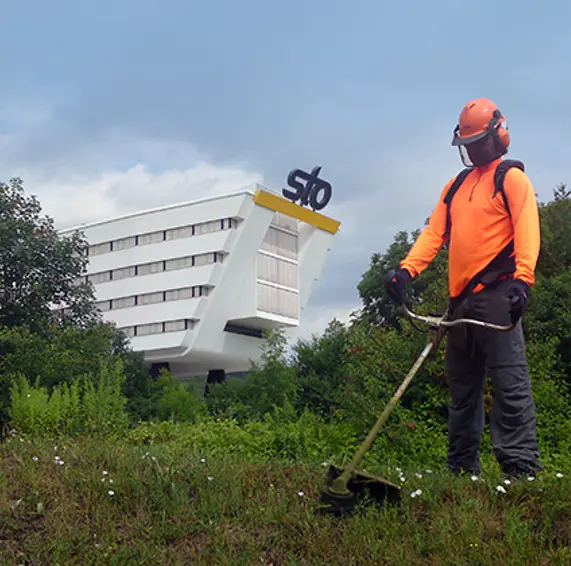 Mann mit Seitenschneider vor STO-Gebäude